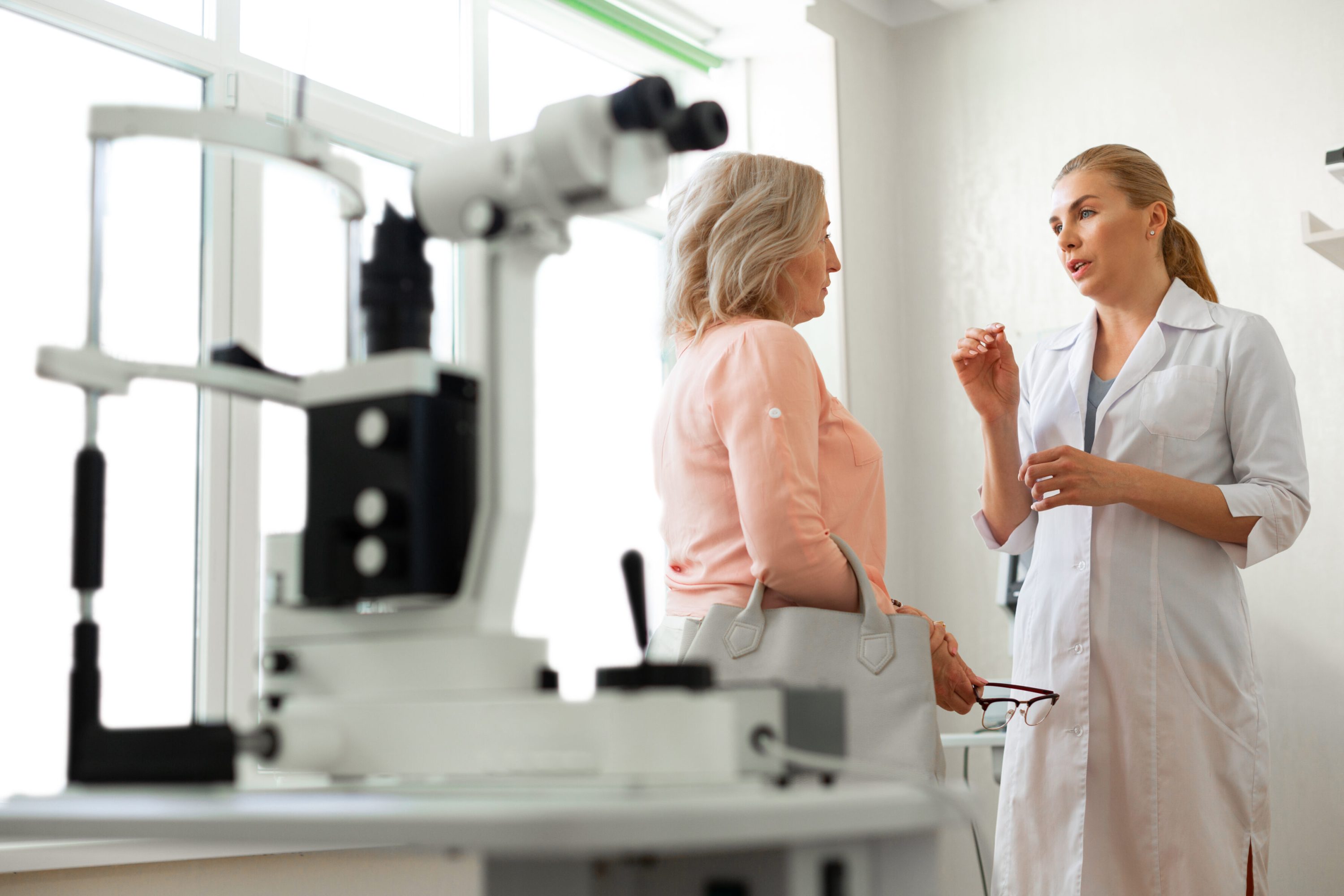 Ophthalmologist explaining a procedure to a patient in an exam room